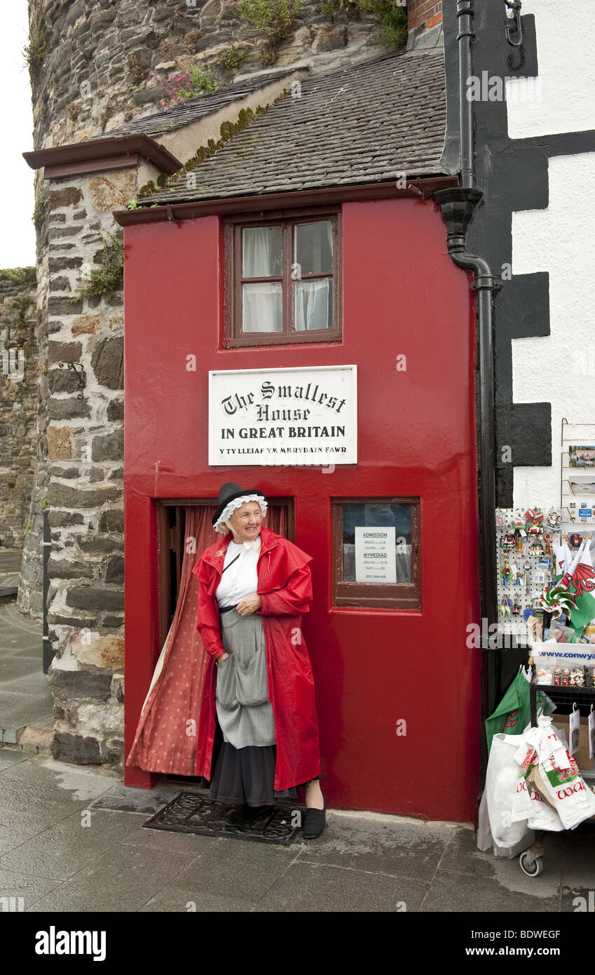 Woman in traditional Welsh costume in front of smallest house in Britain on quayside of North Wales town of Conwy Stock Photo