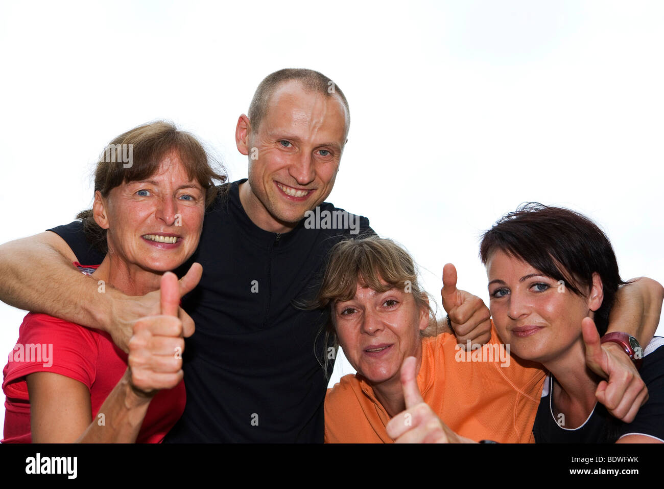 Team of four athletes, thumbs up Stock Photo