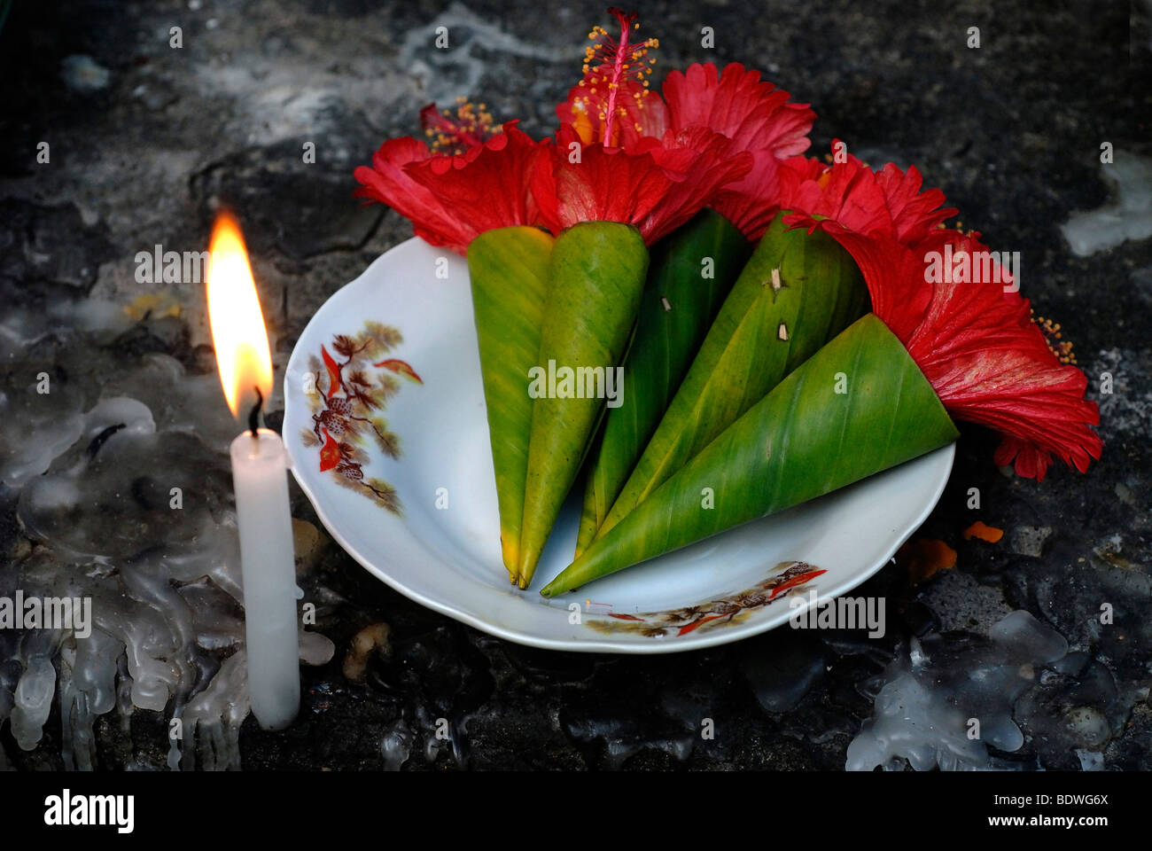 Laotian Buddhist offering with a lit candle at the Mount Phousi, landmark mountain of Luang Prabang on the Mekong, Luang Praban Stock Photo
