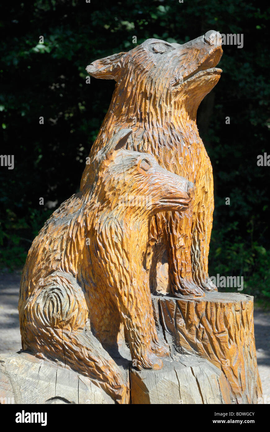 Wooden sculpture of a howling wolf with young wolf, Biosphere Reserve, Fischbach bei Dahn, Palatinate, Rhineland-Palatinate, Ge Stock Photo