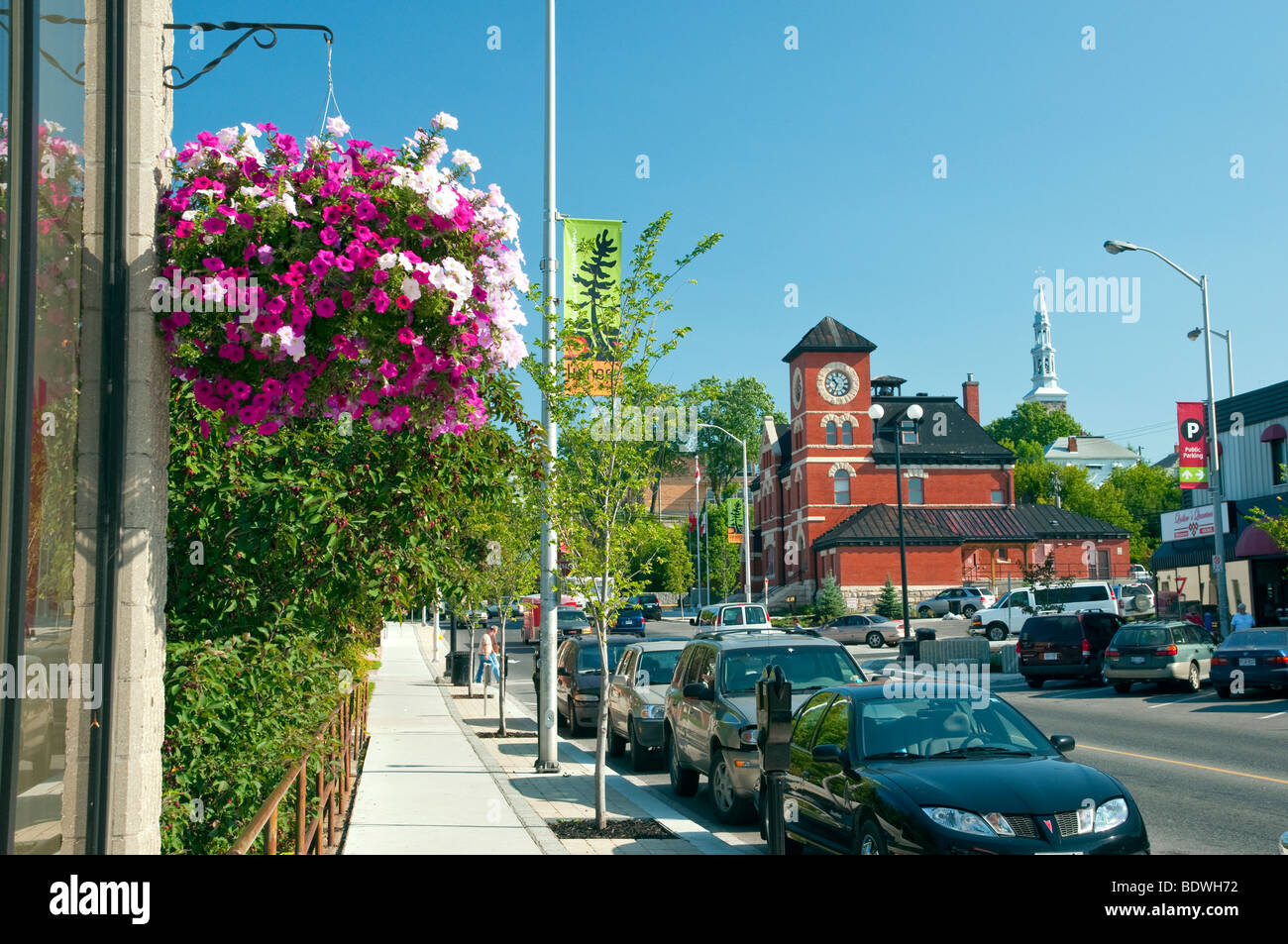 Kenora, Ontario main street with flowers, lamp posts and traffic. Stock Photo