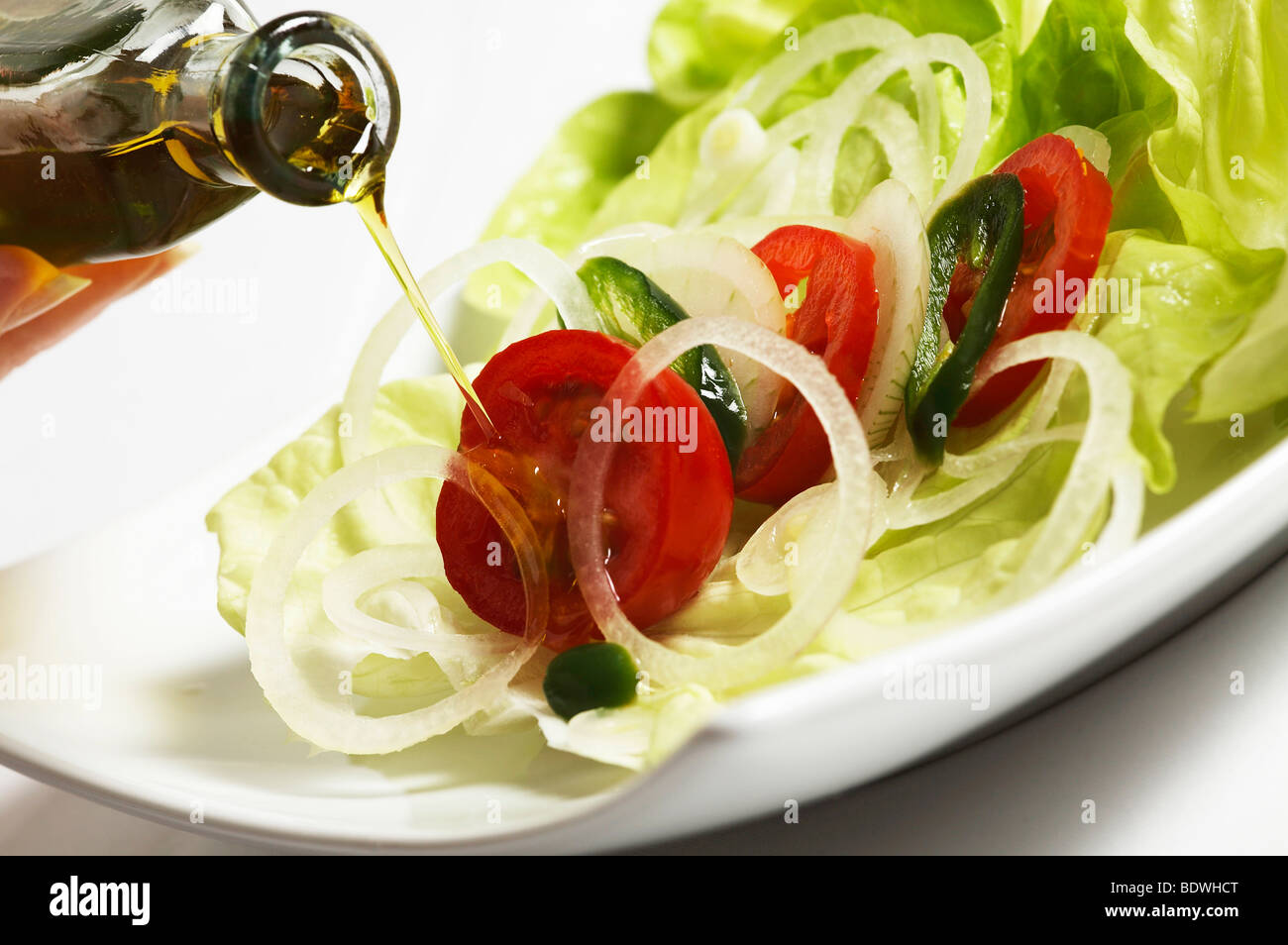 Salad dish, lettuce and tomato, with olive oil Stock Photo