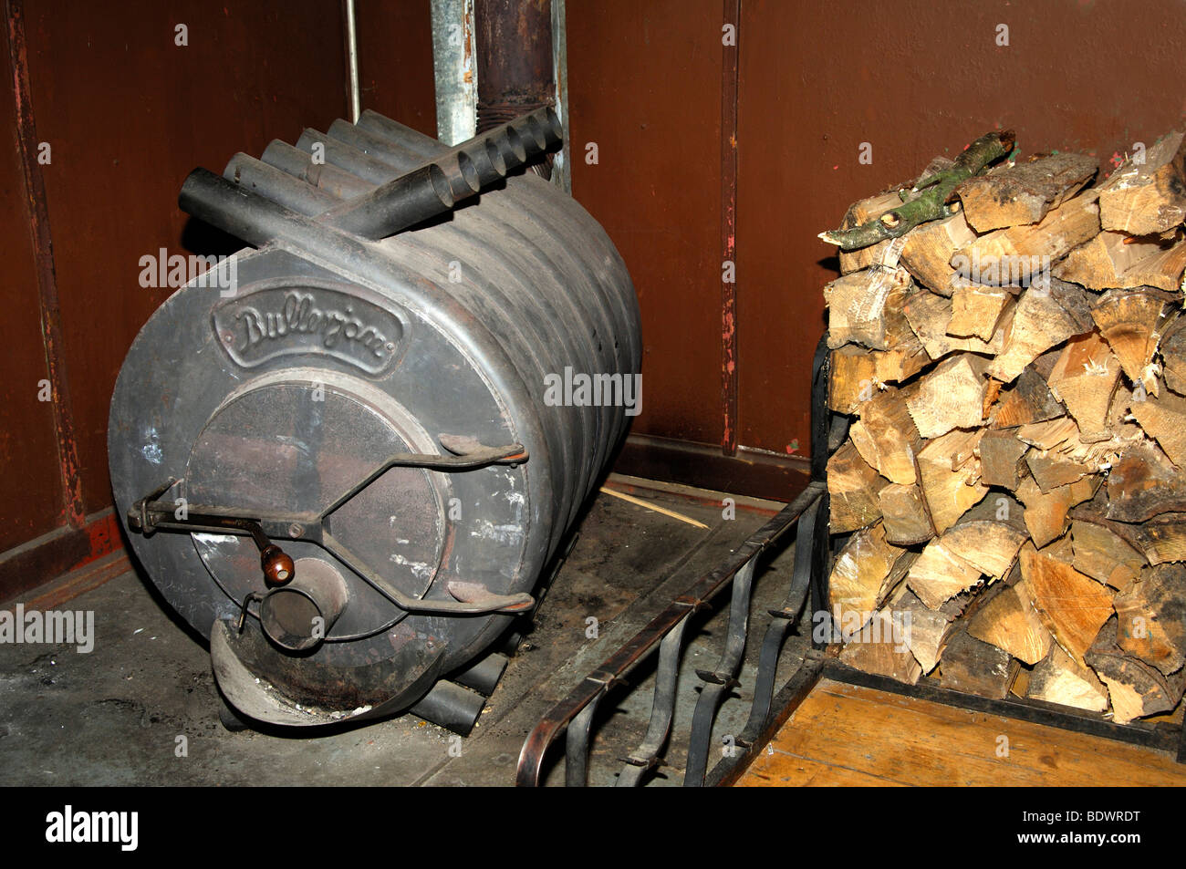 Hot air furnace Bullerjan and a heap of firewood logs Stock Photo