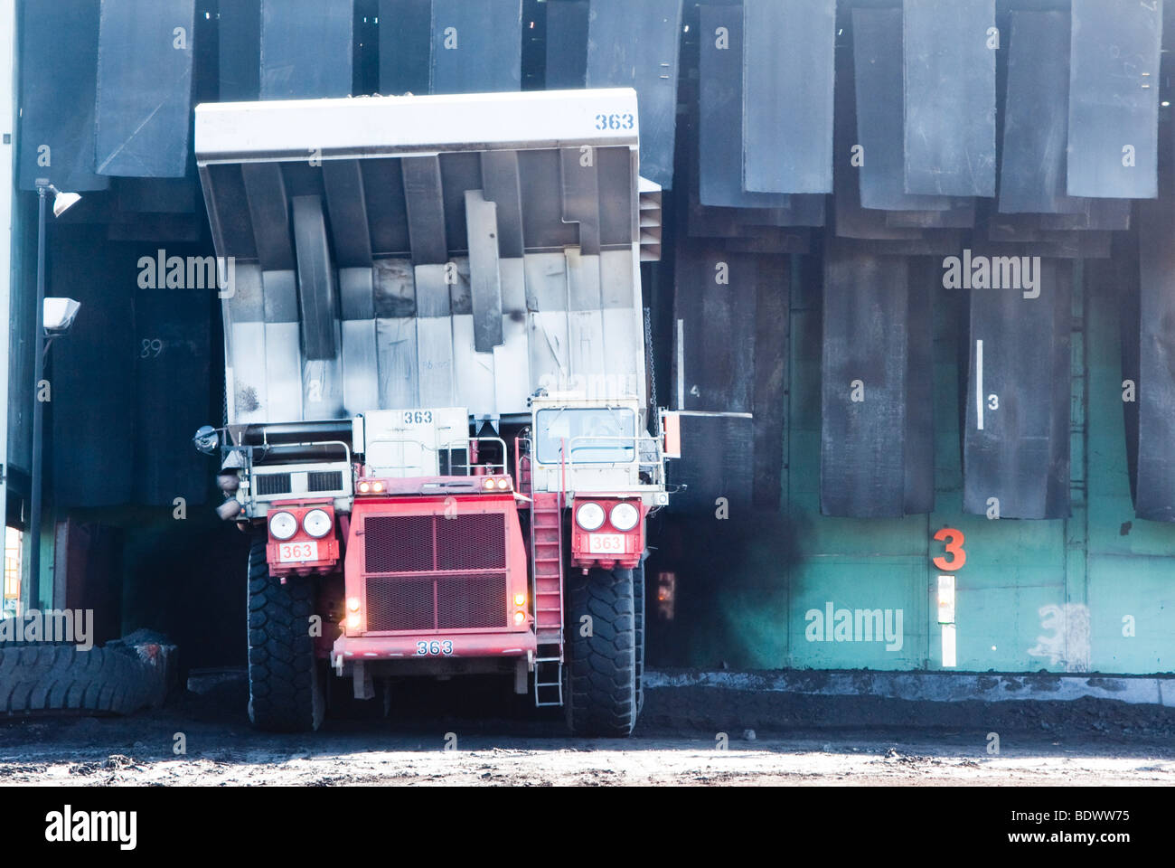 a coal haul truck dumping a load of coal in a hopper in a mine in Wyoming Stock Photo