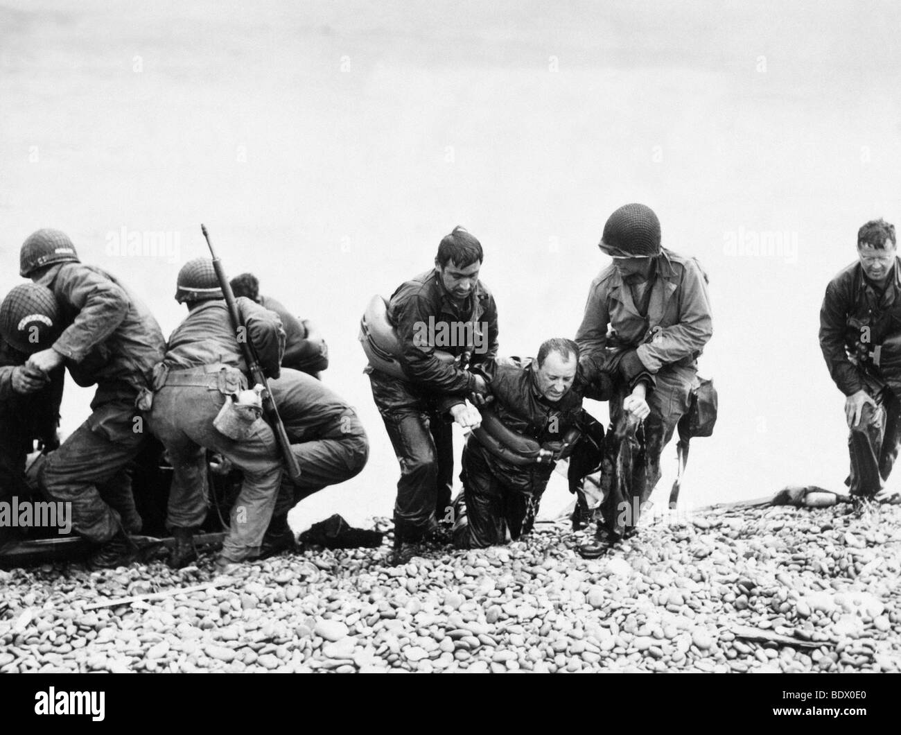 6 JUNE 1944  Half-drowned US soldier helped ashore on Omaha Beach - see description below. Photo J Weintraub Stock Photo