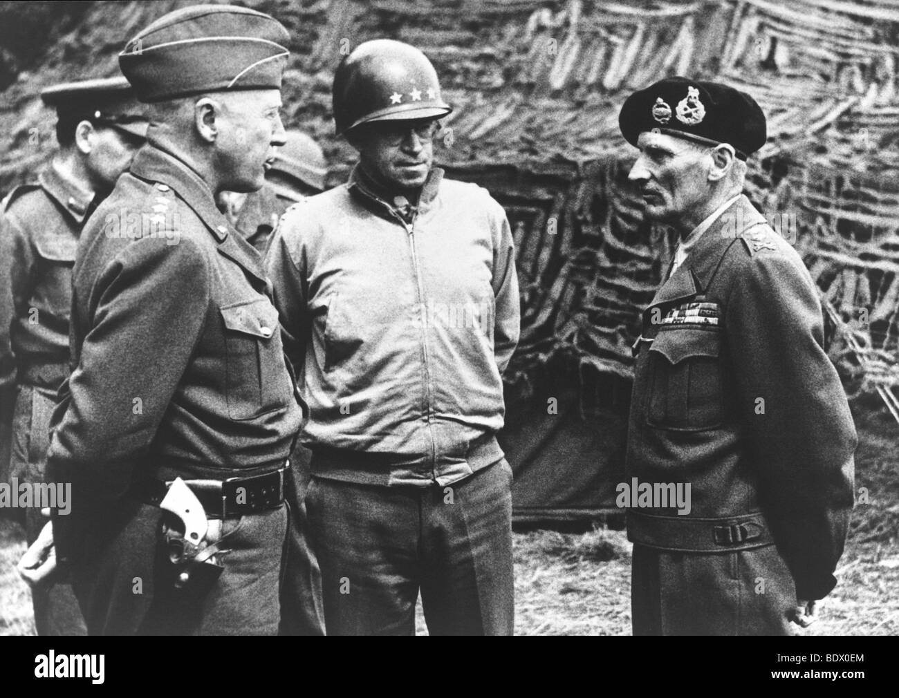 D-DAY 1944 US Generals Patton at left and Bradley meet with Field Marshal Montgomery in France in July 1944.  Description below Stock Photo