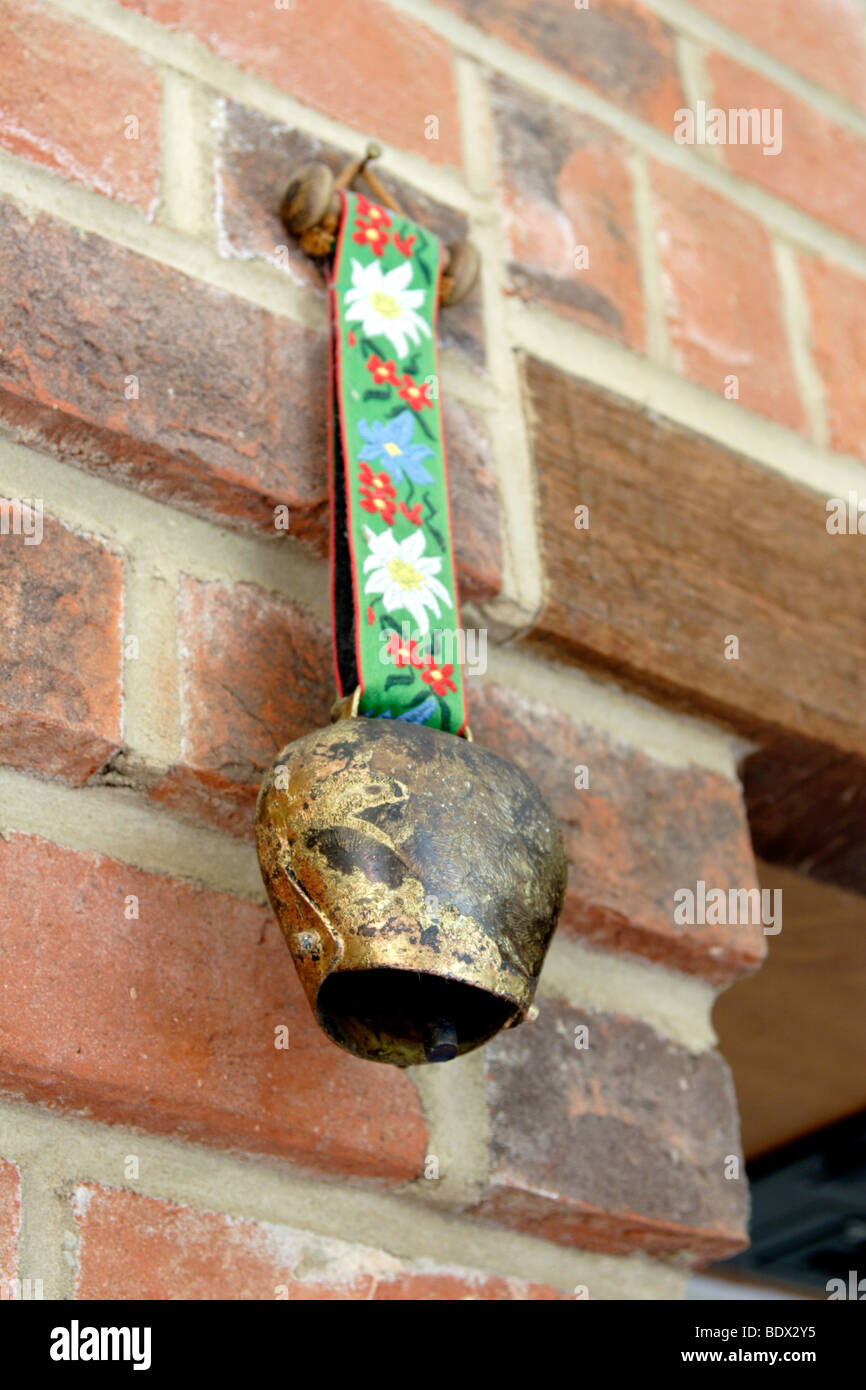 Swiss cow bell hanging on brick wall Stock Photo