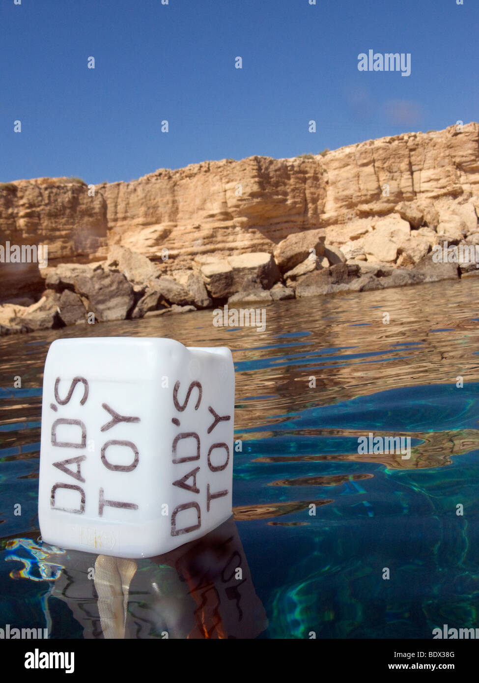 A buoy with the Text: DAD'S TOY. The buoy is situated in the Blue Lagoon near Cape Greco, Cyprus. Stock Photo