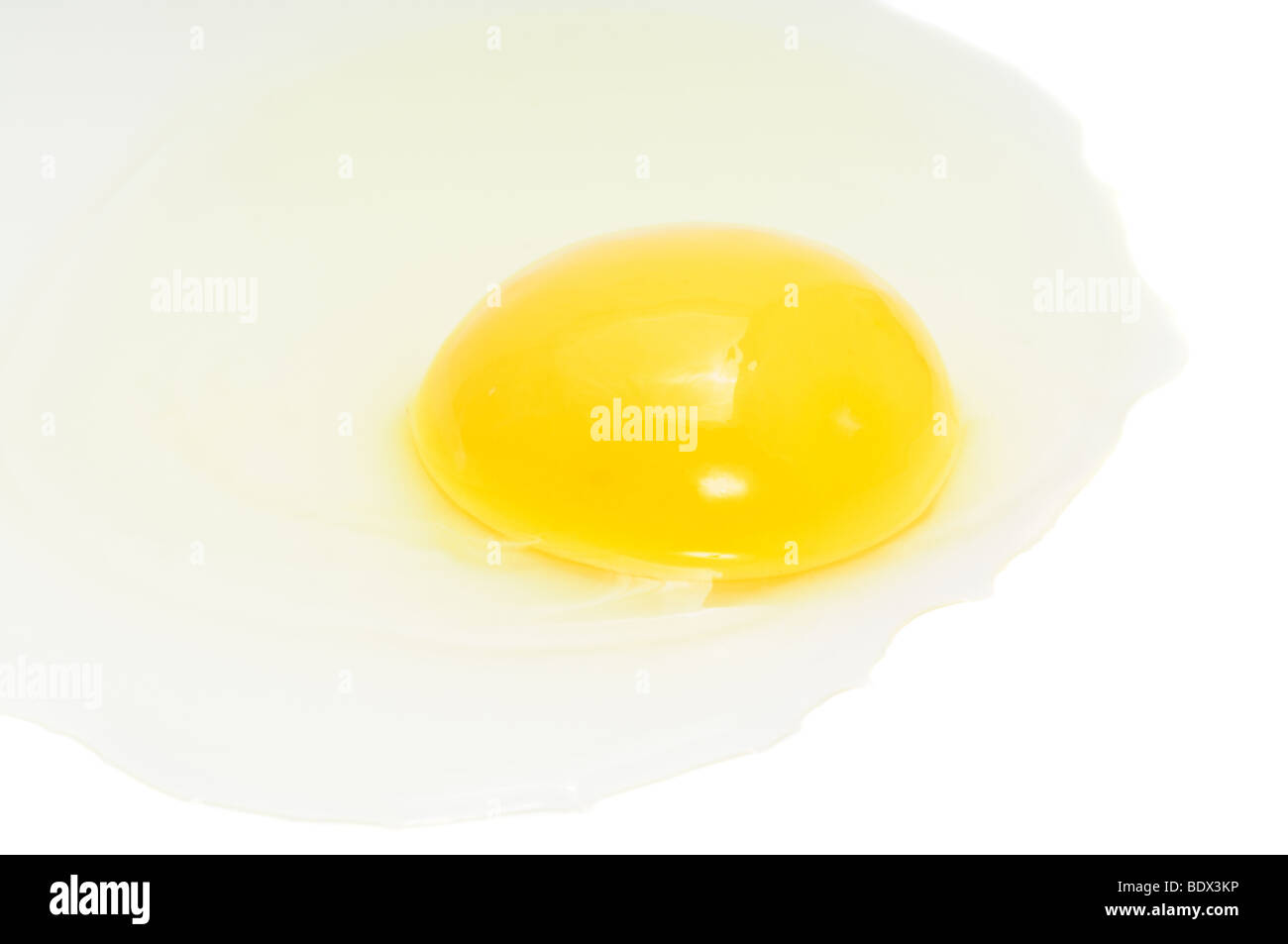 Cracked chicken egg, focus on yolk, isolated on white Stock Photo