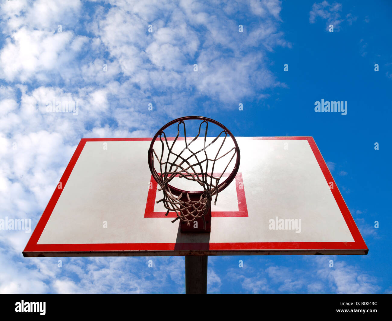 A basketball ring over a blue sky with clouds. Stock Photo