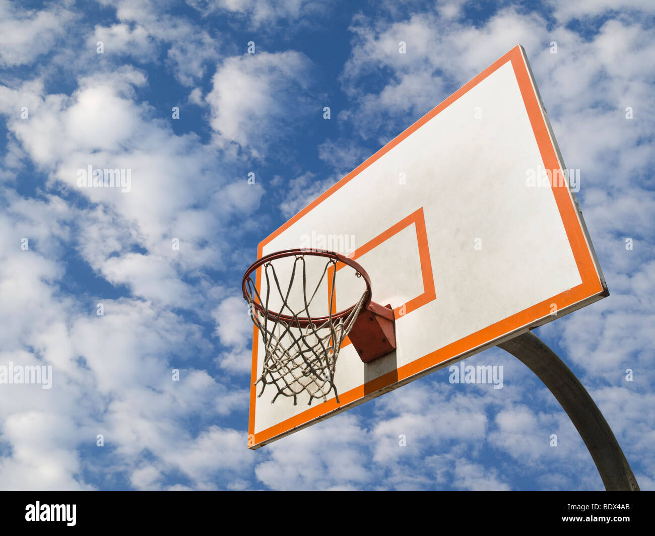 A basketball ring over a blue sky with clouds. Stock Photo