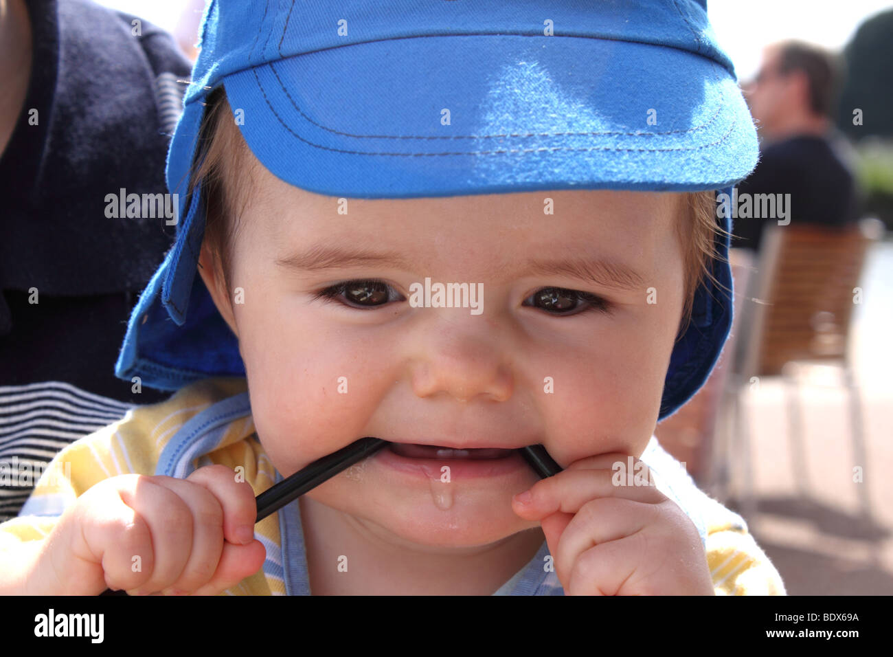 Baby boy teething,dribbling and chewing a straw Stock Photo