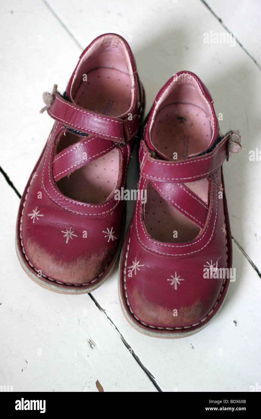 Pair of scuffed shoes on white wooden floorboards Stock Photo