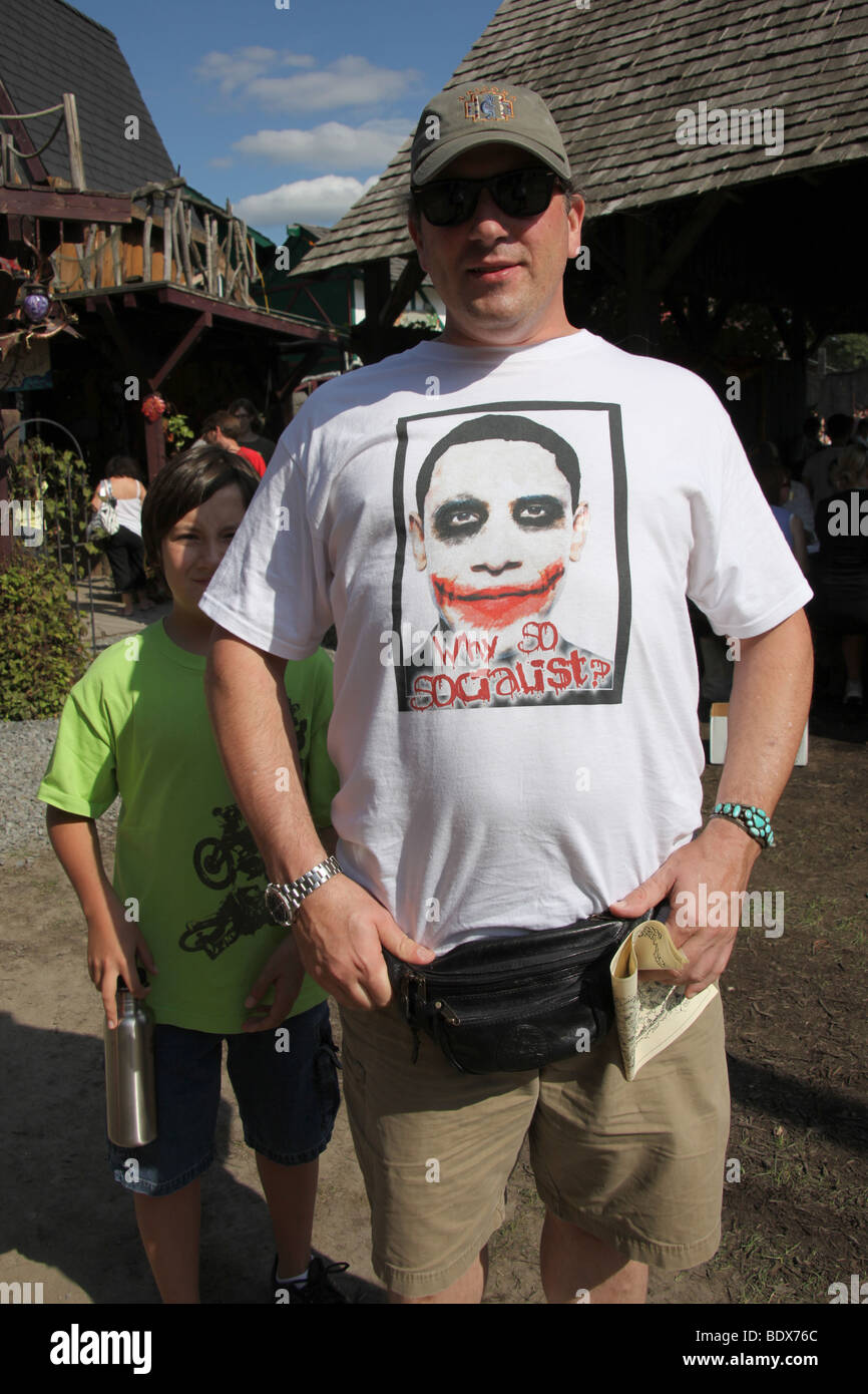 American man wearing anti-Obama t-shirt at a festival, his young son by his side.  Orange County, New York. Katharine Andriotis Stock Photo