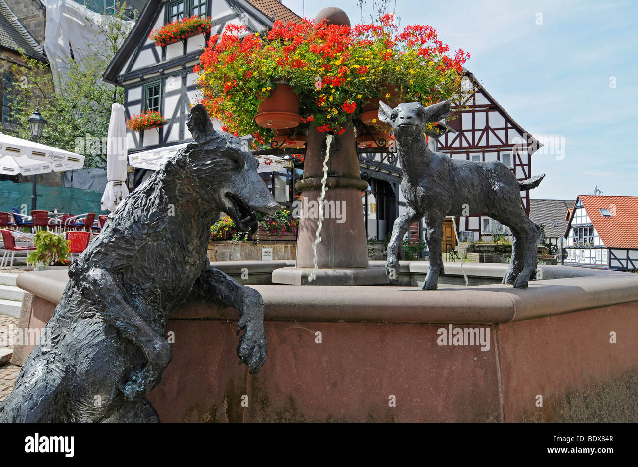 Fountain with sculptures of a wolf and a lamb on the market square with halftimbered houses