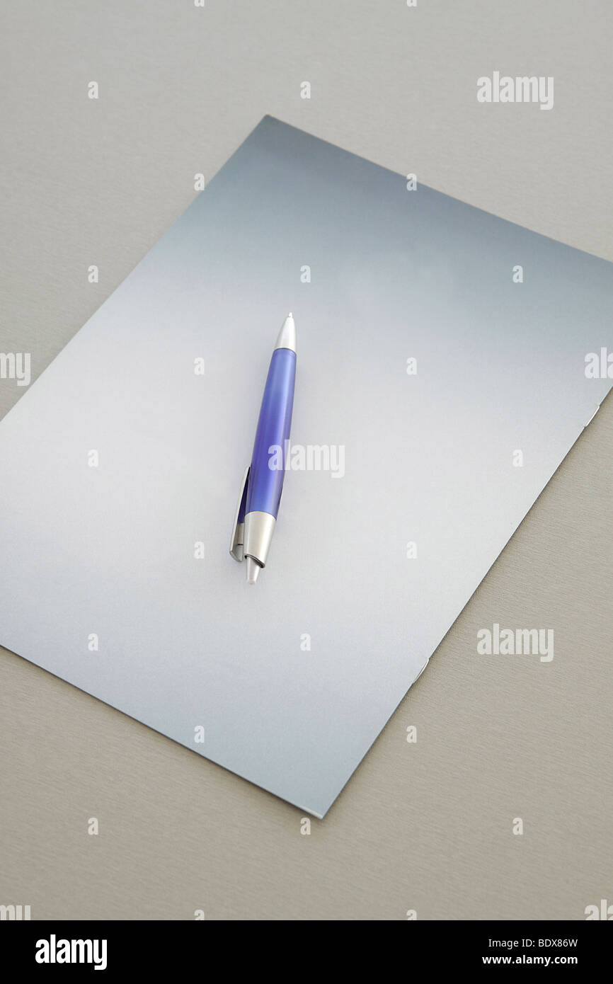 Blue Pen on a grey notebook Stock Photo