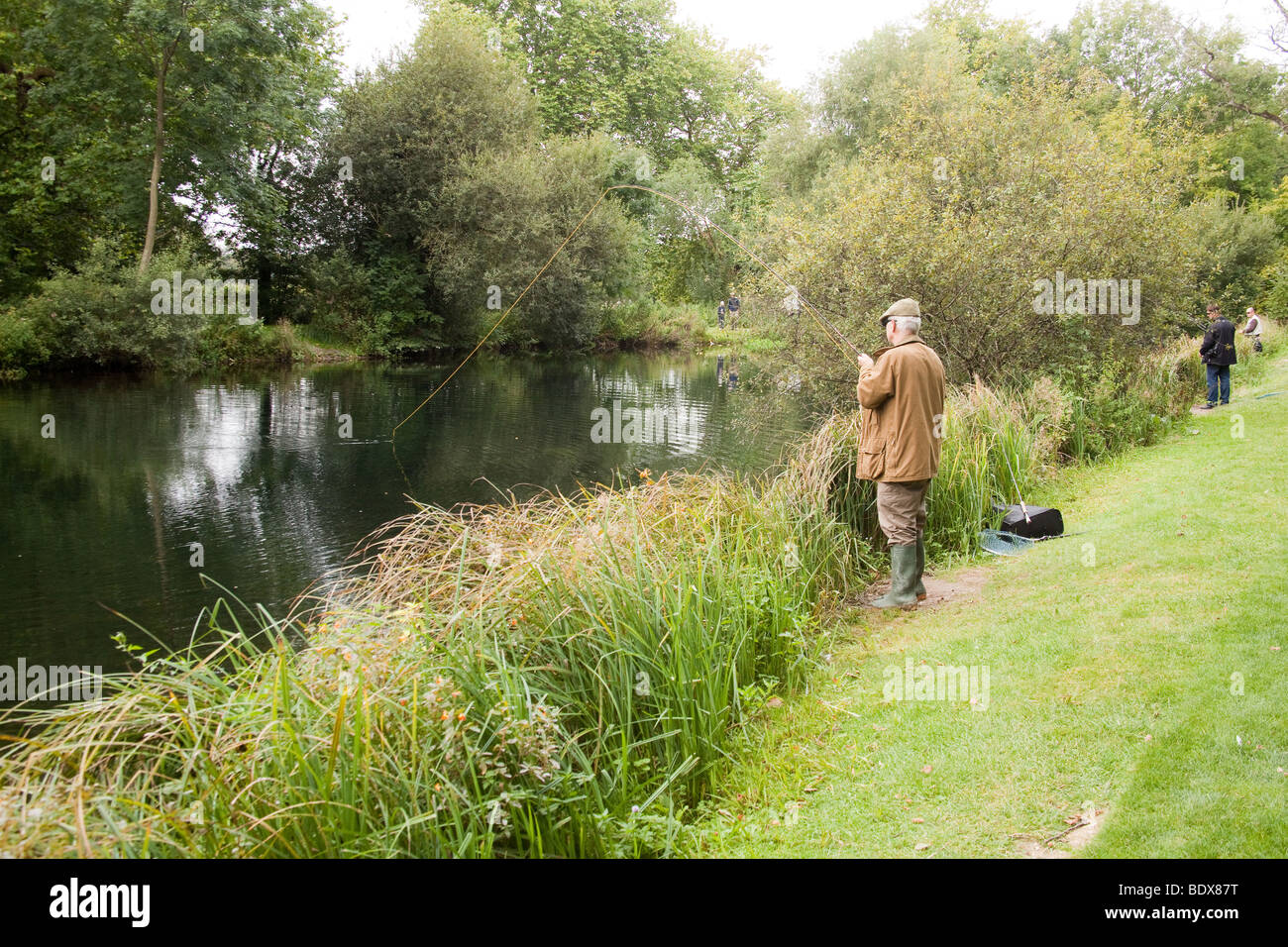 Fly fisherman fishing for trout at Avington Fishery, Hampshire, England