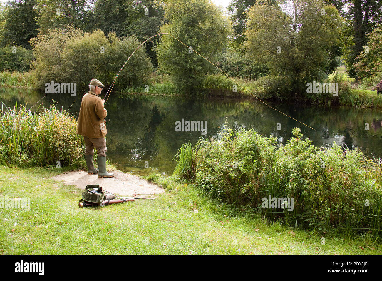 Fly fisherman fishing for trout at Avington Fishery, Hampshire, England