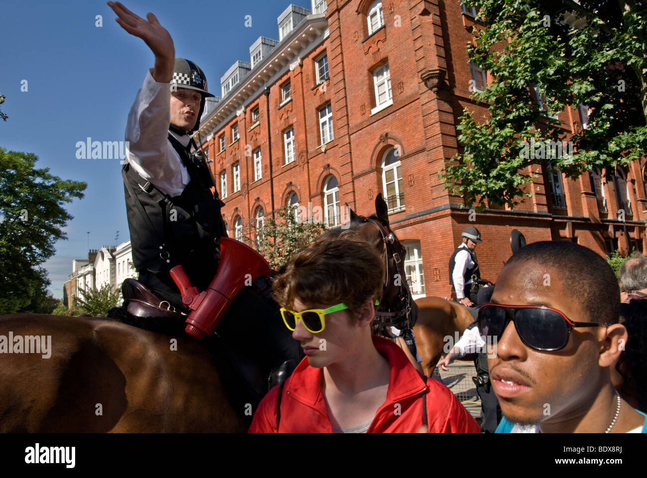 MOUNTED POLICEMAN GIVES DIRECTION TO THE CROWD DURING THE NOTTING HILL CARNAVAL 2009 Stock Photo