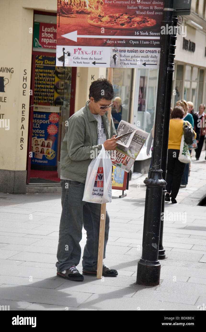 A signboard holder reads a newspaper, Bath, UK Stock Photo Alamy