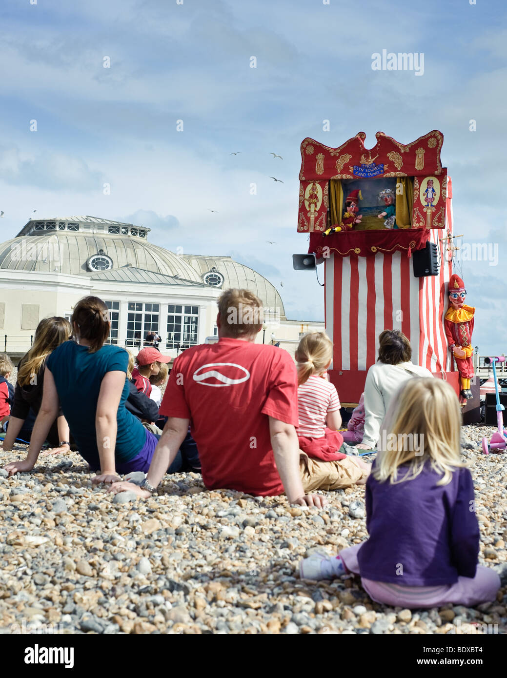 Families enjoy a Punch and Judy Show by the Sea Stock Photo