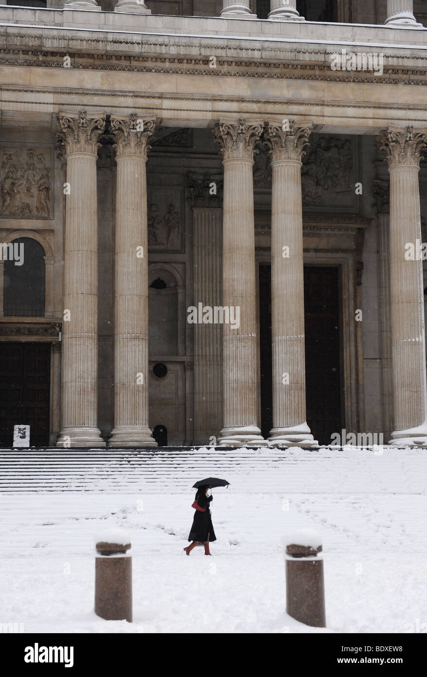 A woman walking by St Paul's Cathedral, London, in the snow. Stock Photo