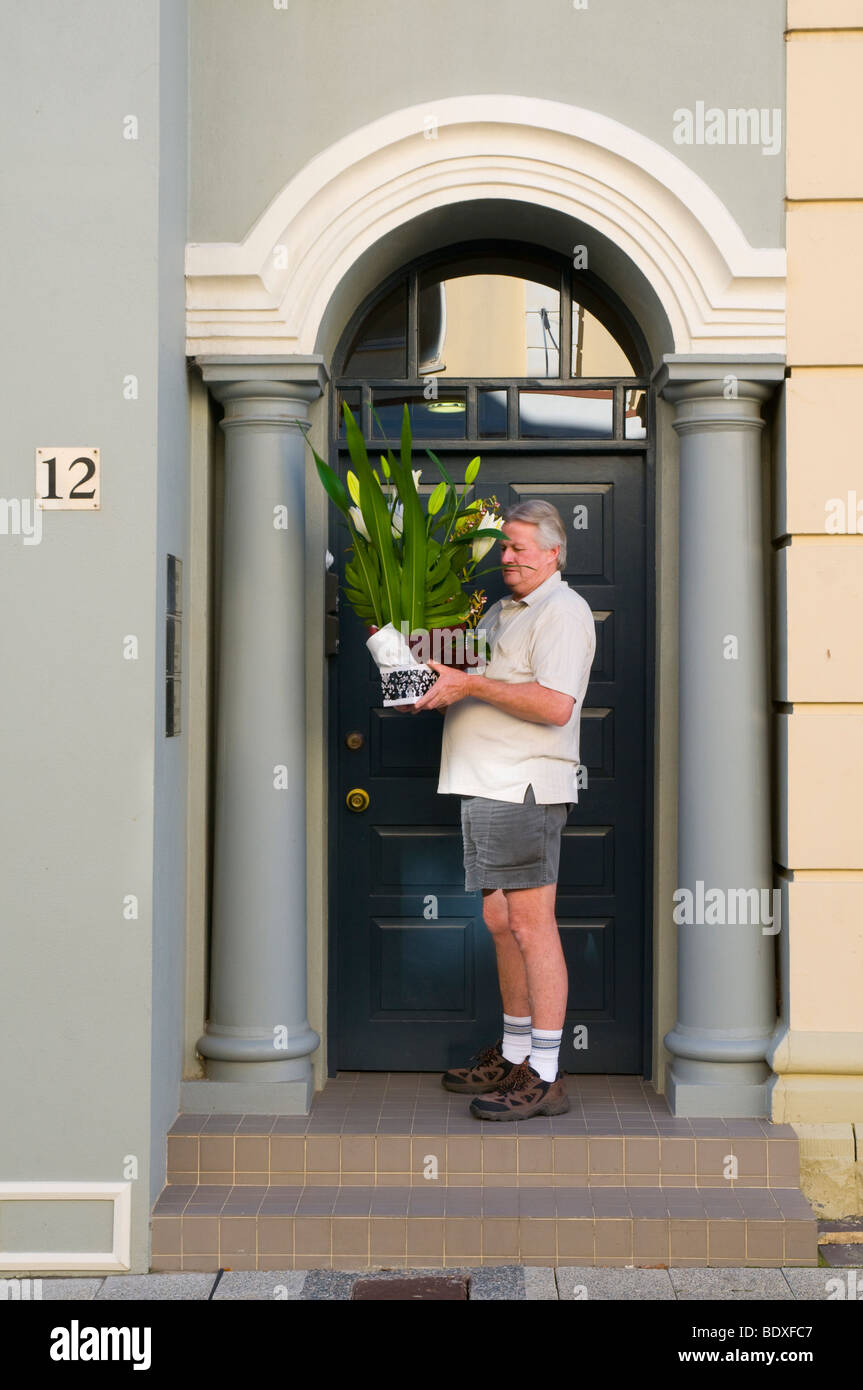 Courier ringing doorbell to deliver plants in Fremantle Western Australia Stock Photo