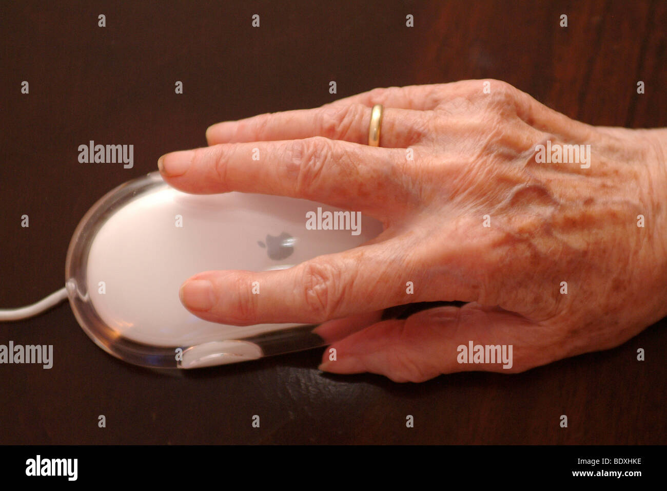 Aged hand with computer mouse Stock Photo