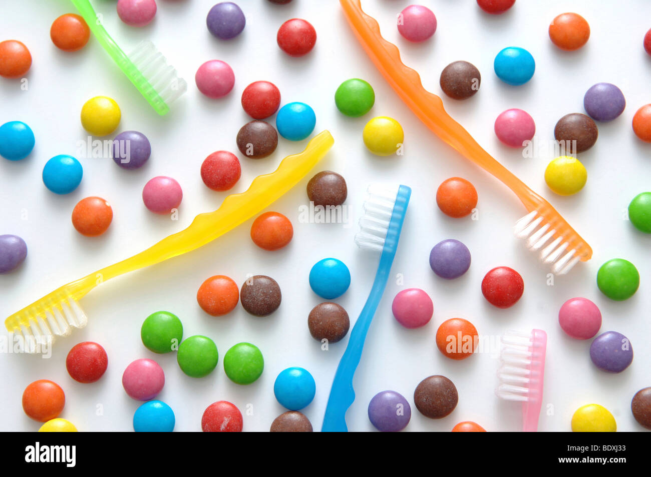 Colorful chocolate candies and toothbrushes Stock Photo
