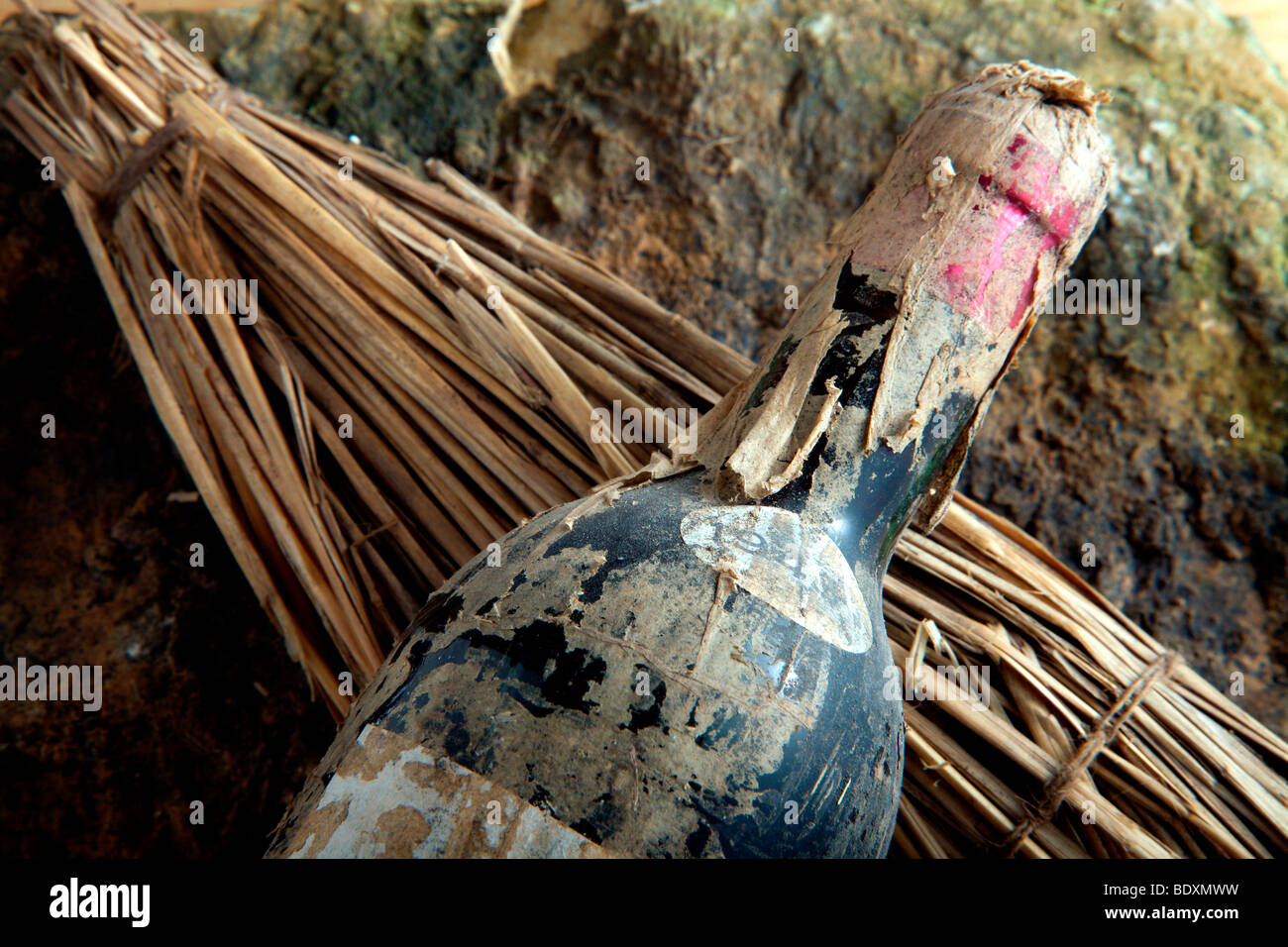 Old bottle of red wine on straw Stock Photo