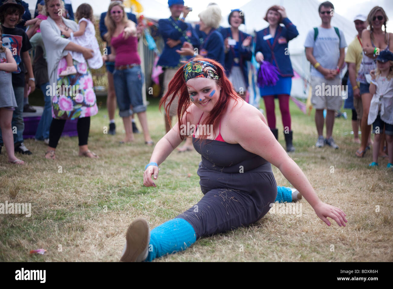 A woman daces and does the splits at Camp Bestival 2009 at Lulworth Casle in Lulworh, Dorset. Stock Photo