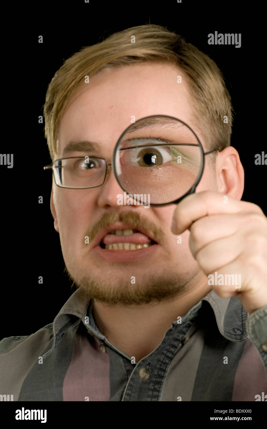 man face with eye magnified through loupe on black background Stock ...