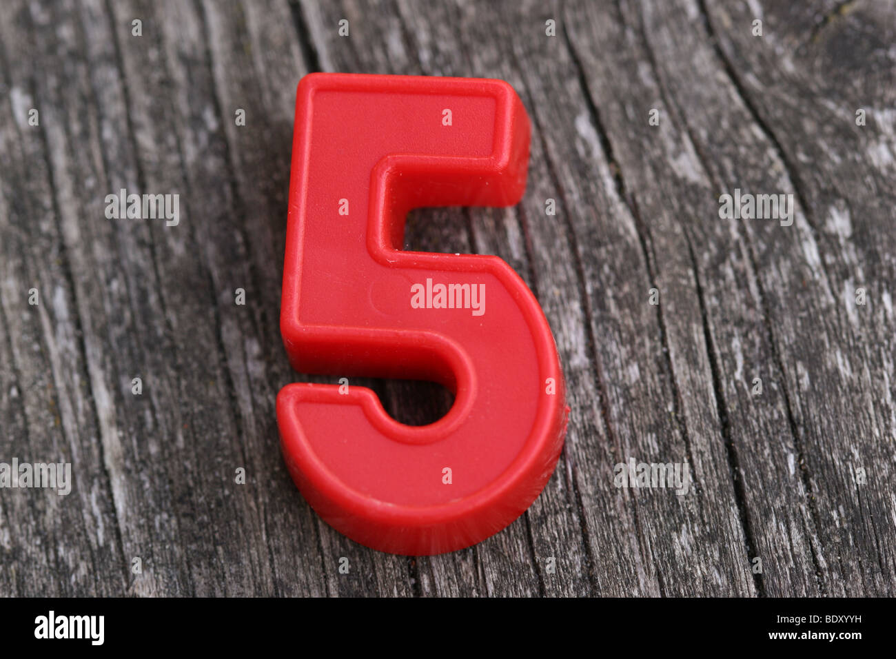 Red magnetic Number Five on Wood Stock Photo