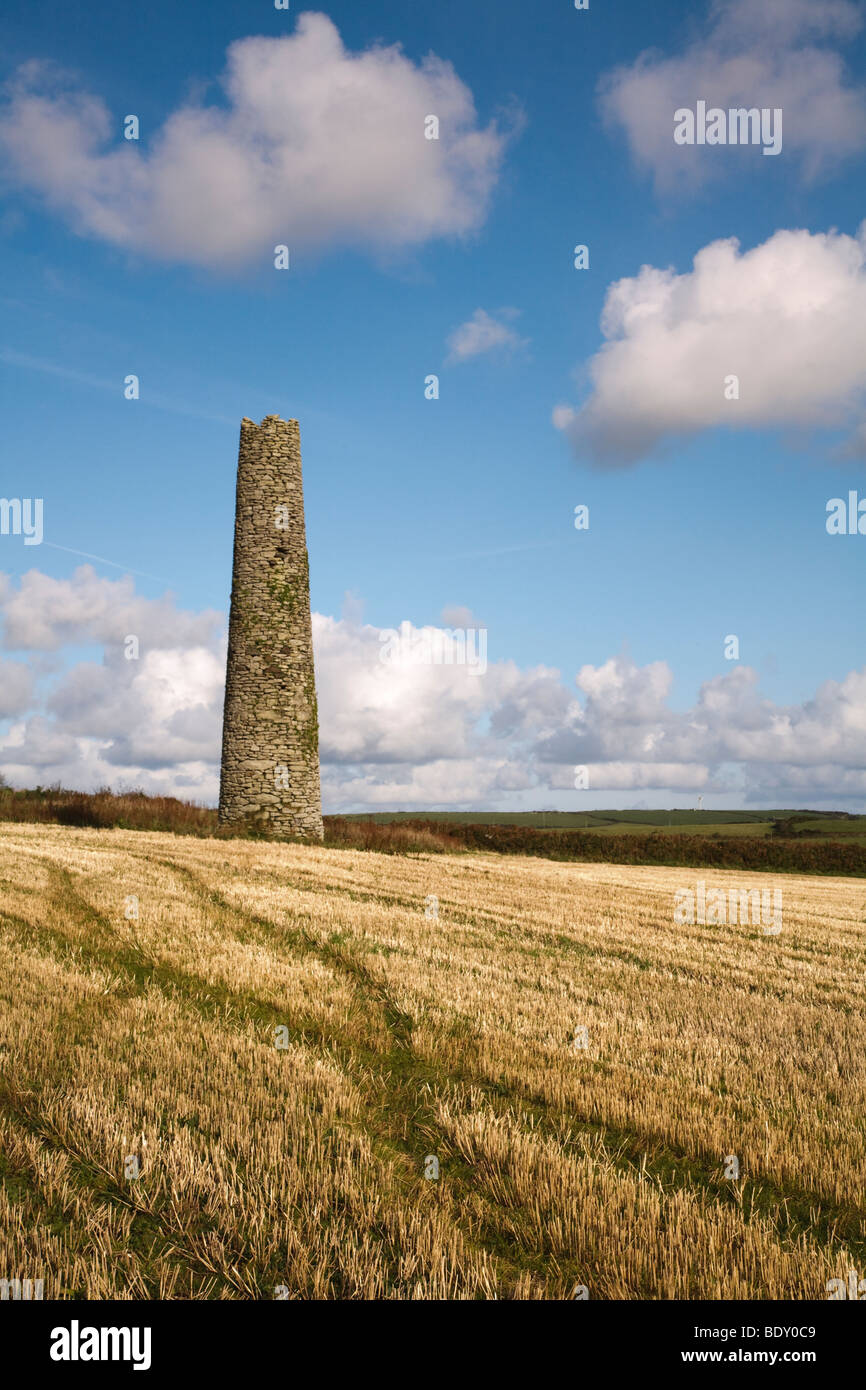 A ruined chimney stands isolated in the landscape of Cornwall, UK Stock Photo
