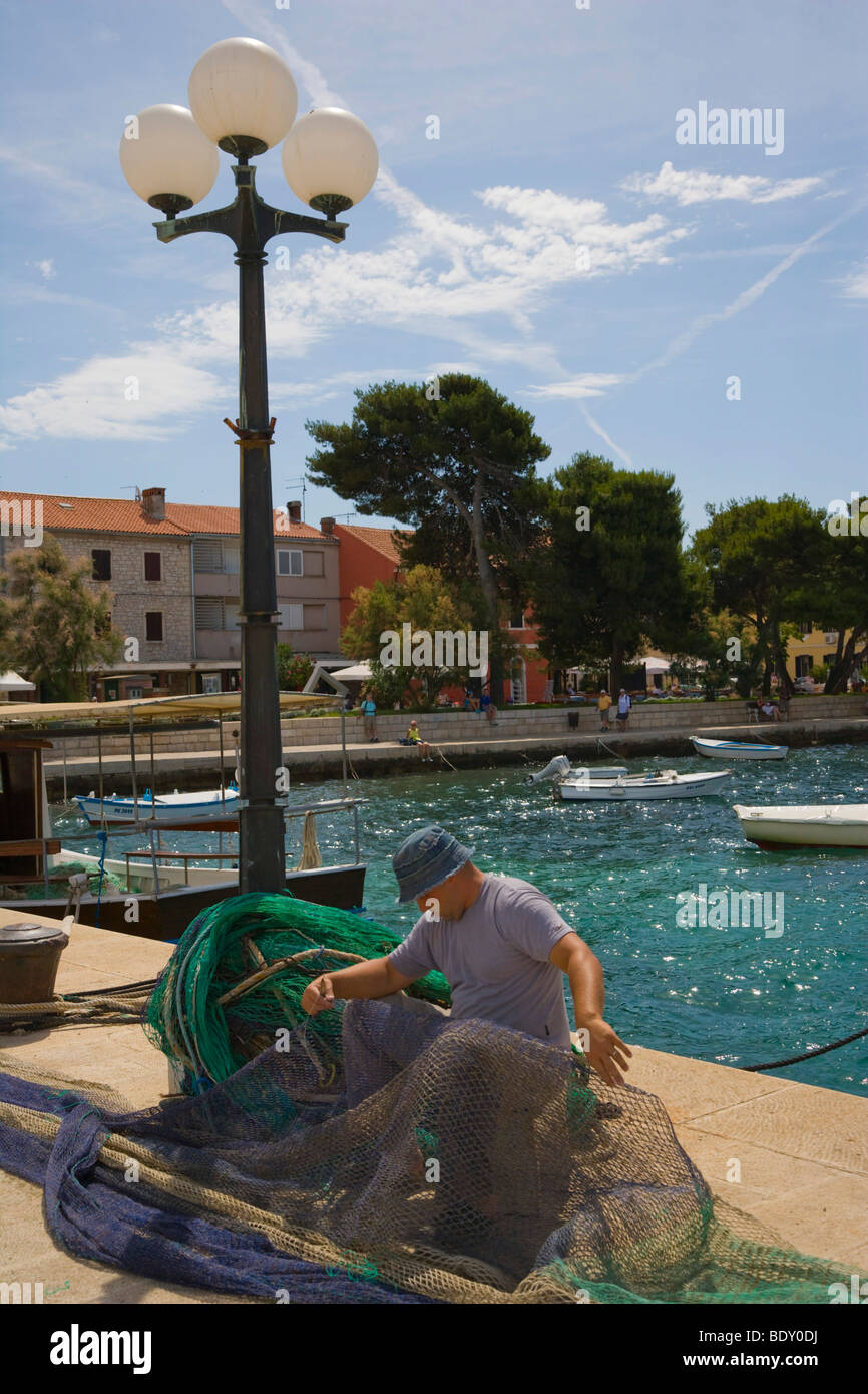 Fisherman fixing net, Harbour of Fazana, Istria, Croatia, Europe Stock Photo
