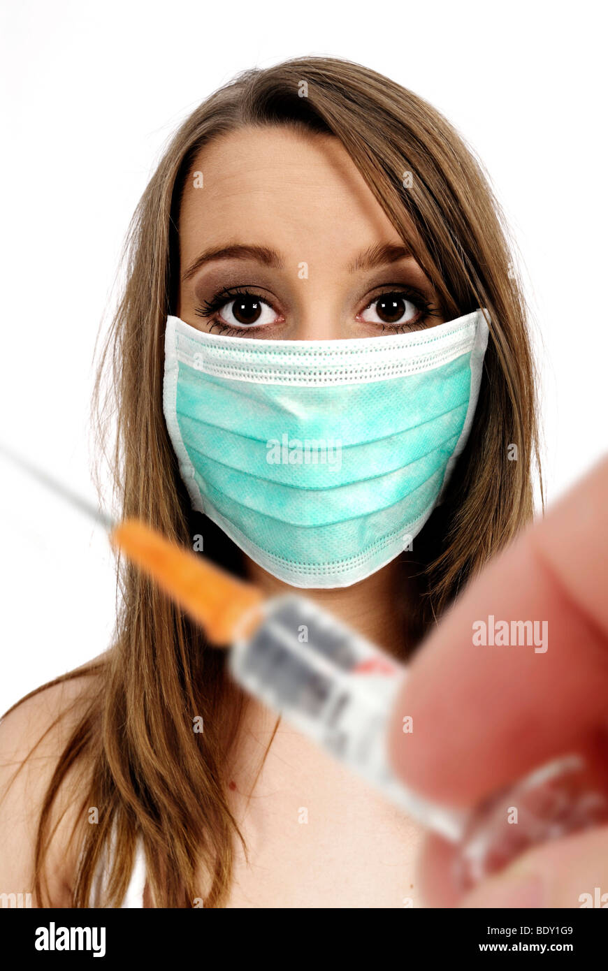 Woman wearing a face mask, and a hand holding a syringe, vaccination against swine flu Stock Photo