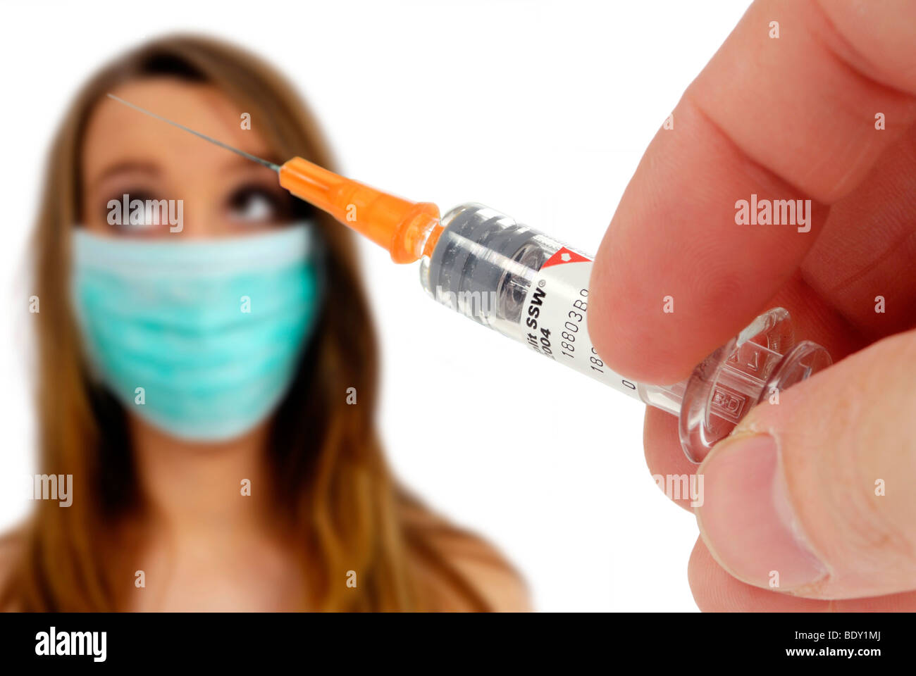Woman wearing a face mask, and a hand holding a syringe, vaccination against swine flu Stock Photo