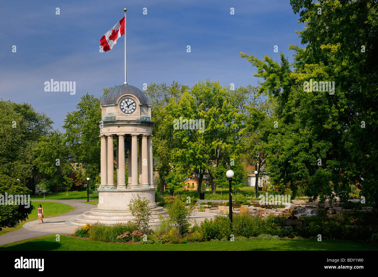 Old City Hall Clock Tower and fountain in Victoria Park Kitchener with Canadian flag Stock Photo