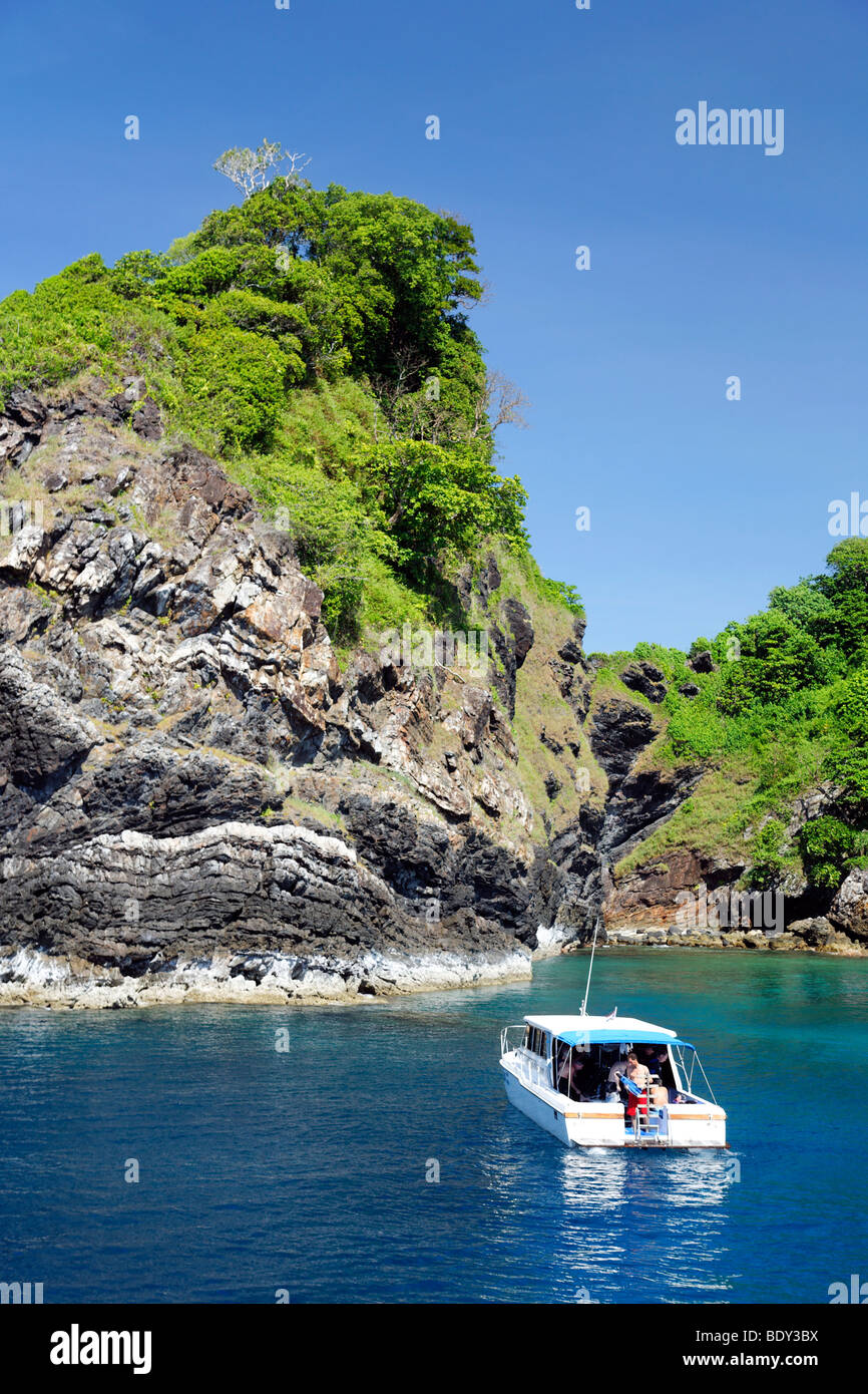 Dive ship anchored in front of greenclad cliffs, Similan Islands