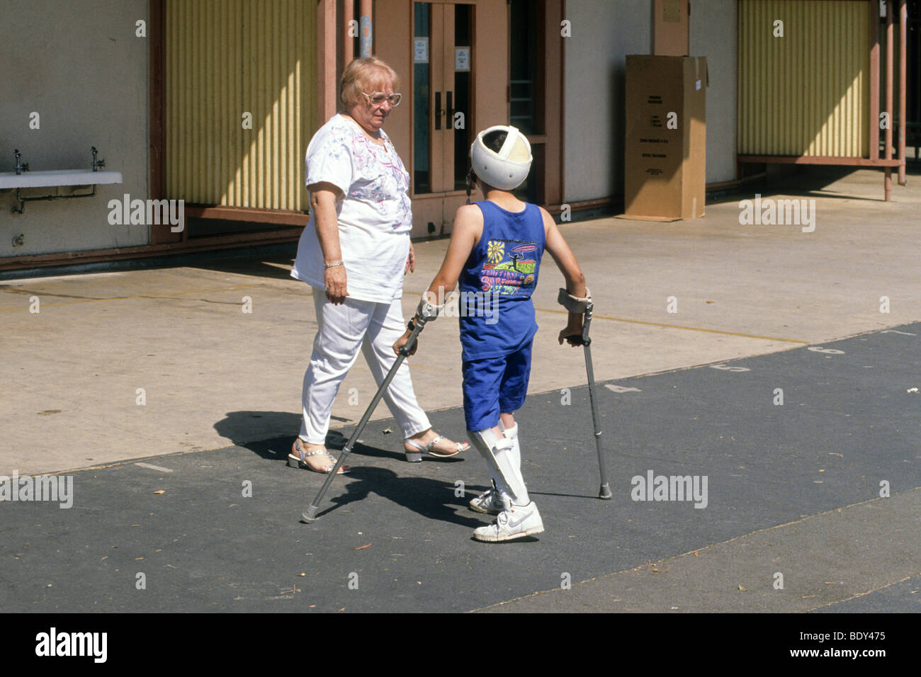 Handicapped school is assisted with crutches in special school designed
