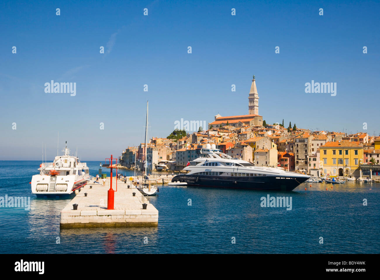 The pier of the southern harbour with motor yacht Sibelle and catamaran against Rovinj historic centre, Istria, Croatia, Europe Stock Photo
