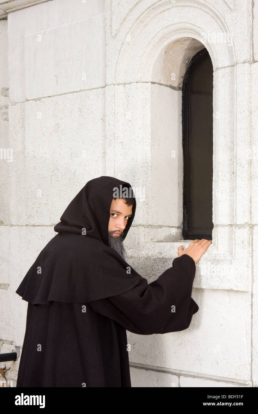 Halloween scene of a black hooded monk at a chapel Stock Photo