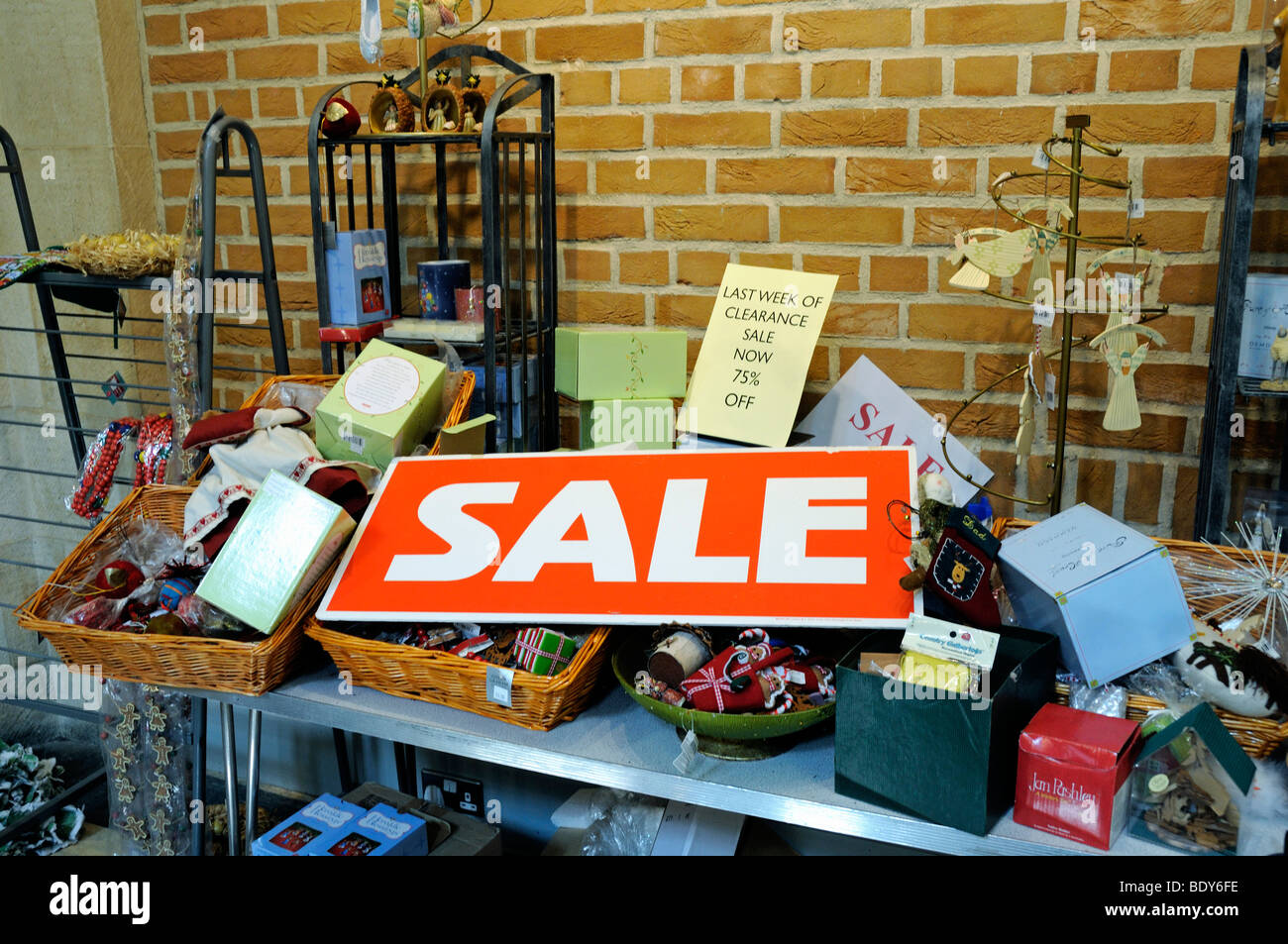 Sale sign in red and white on stall with clearance goods behind Stock Photo