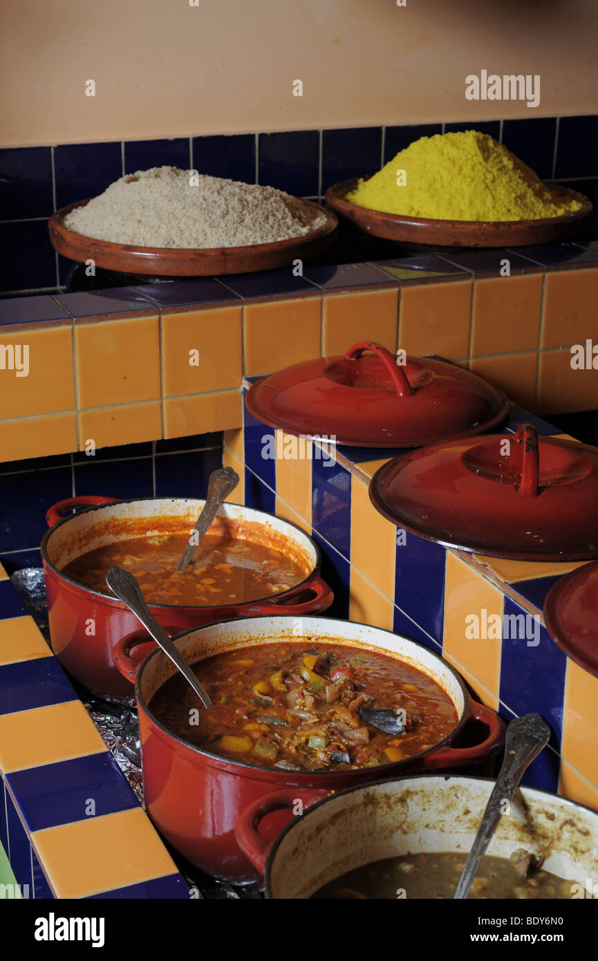 Traditional Moroccan cuisine. Simmering pots of meat and vegetables different varieties of Steamed Cuscus can be seen Stock Photo