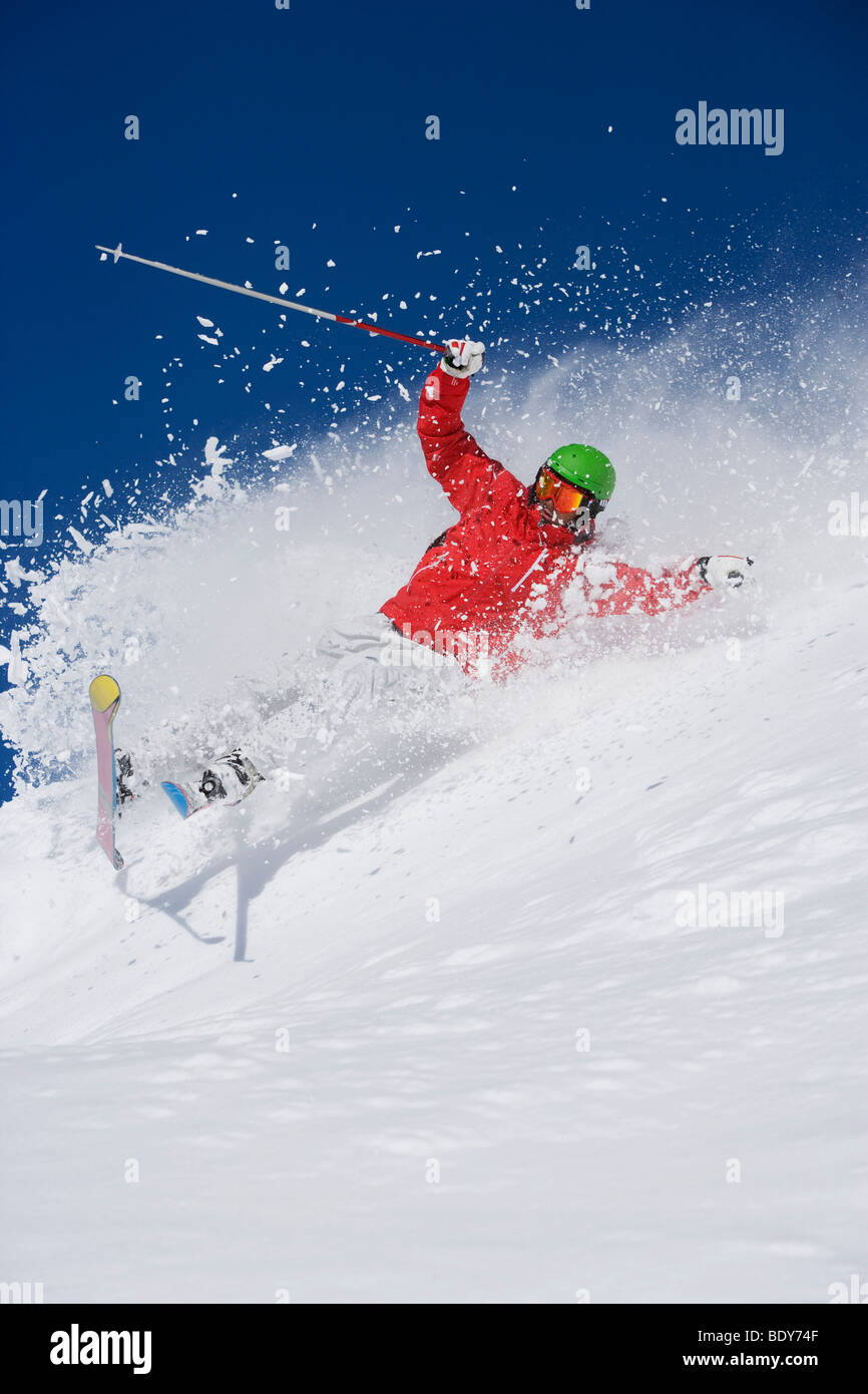 Man in red falling mid carve off-piste. Stock Photo