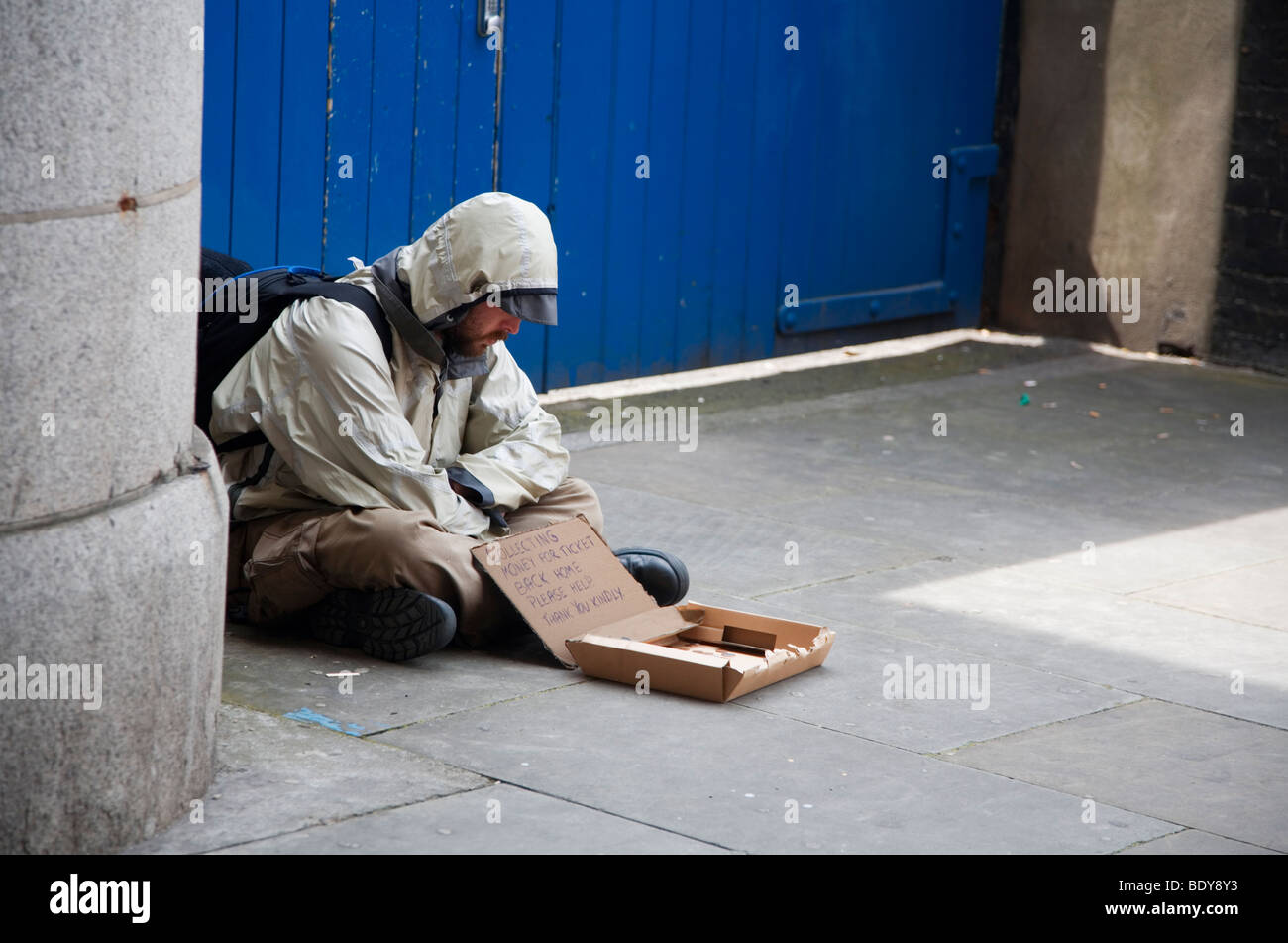 Man sitting on pavement, begging for money for his return ticket home, London, Soutbank, England, summertine evening. Stock Photo