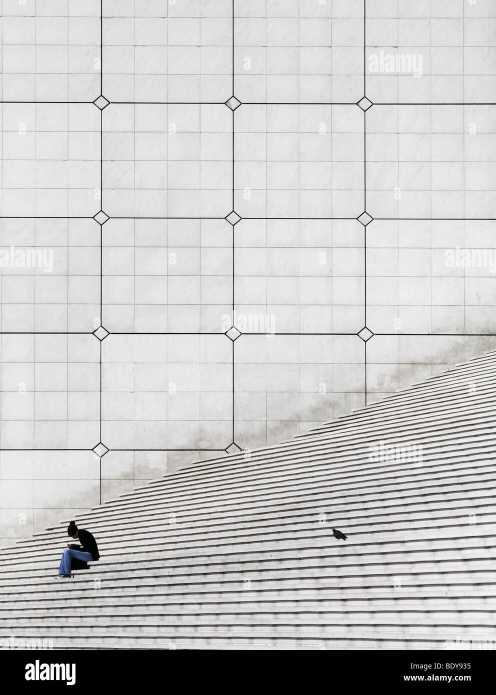 Woman and dove on stairs, La Grande Arche, La Defense, Paris, France, Europe Stock Photo