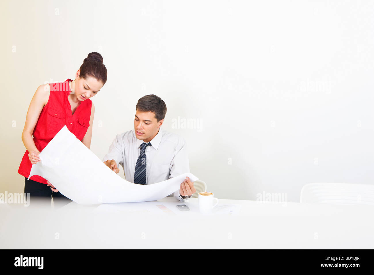 Two colleagues conferring over plans Stock Photo