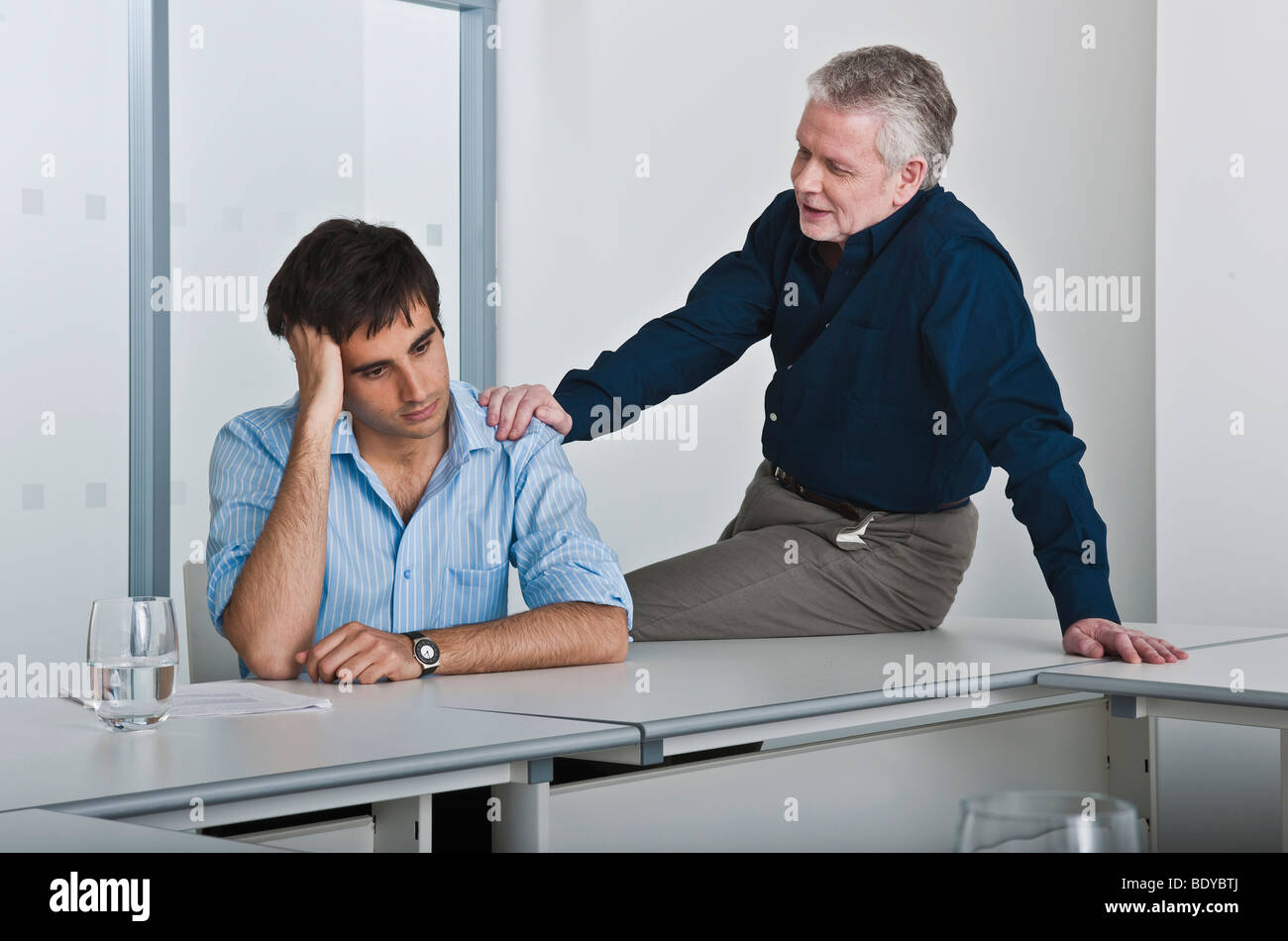 man consoling work colleague Stock Photo
