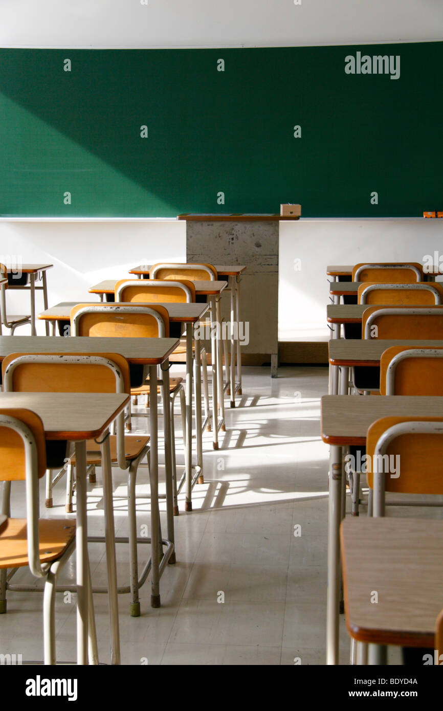 Empty classroom. Only school desks, chairs and a blackboard. No students. Stock Photo